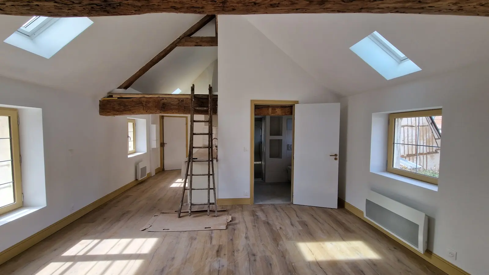 Espace sous combles rénové avec charpente apparente